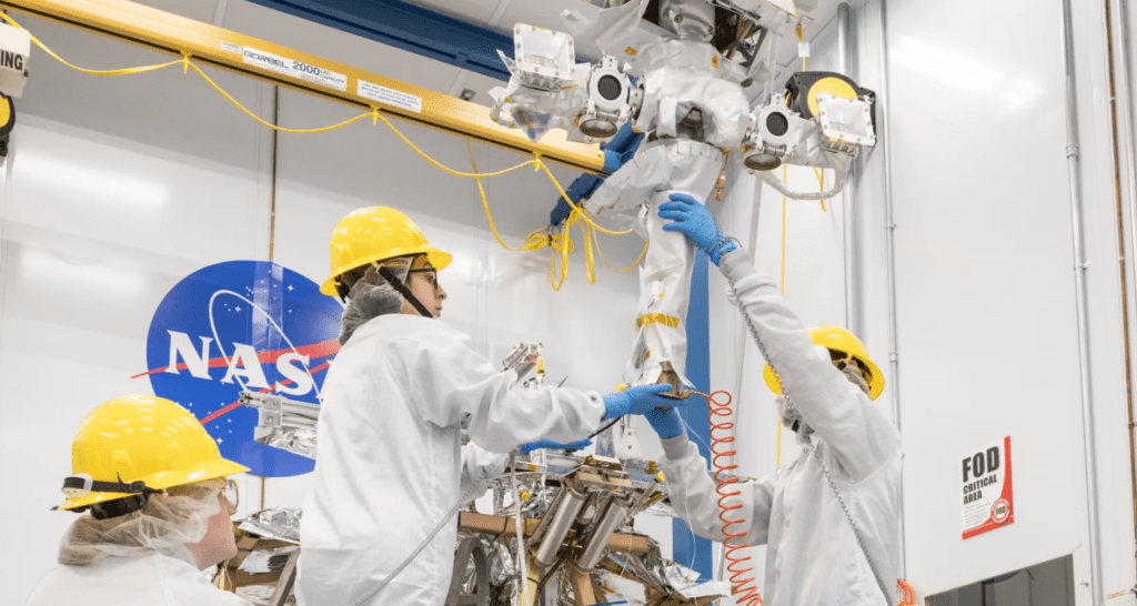 Un team di ingegneri solleva la struttura portante del rover lunare VIPER della NASA in una camera bianca al Johnson Space Center di Houston. Credits: NASA/Helen Arase Vargas