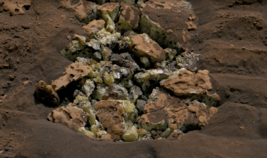 Questi cristalli gialli sono stati rivelati dopo che il rover Curiosity della NASA è passato sopra una roccia e l'ha rotta, lo scorso 30 maggio 2024. I cristalli sono di zolfo elementare. Credits: NASA/JPL-Caltech/MSSS